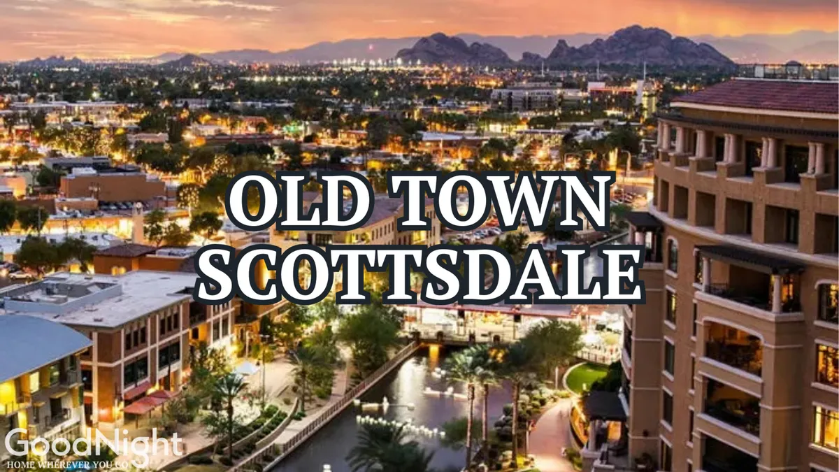 This image features the iconic Old Town Scottsdale sign overlooking a scenic waterway, with bustling buildings and distant mountains as a backdrop. People are seen strolling along the walkway, enjoying the lively atmosphere of the area.