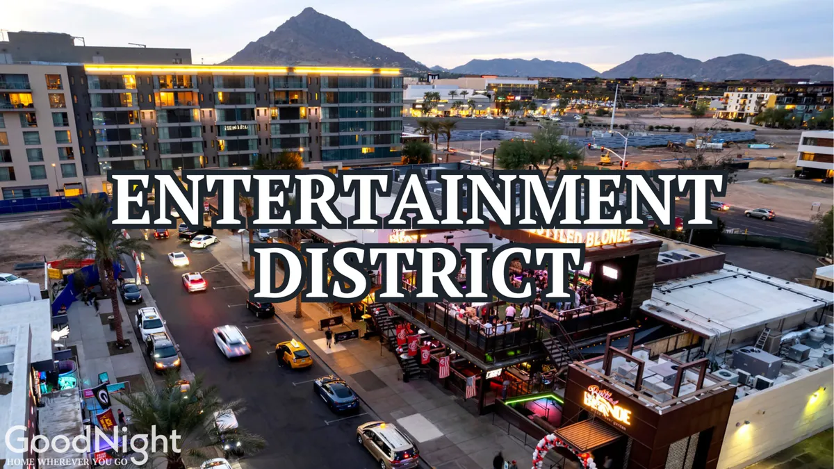 The scene captures a busy street in Old Town Scottsdale, lined with entertainment venues, restaurants, and shops, with people enjoying the lively nightlife. The mountain backdrop adds a sense of place and excitement to the urban energy.